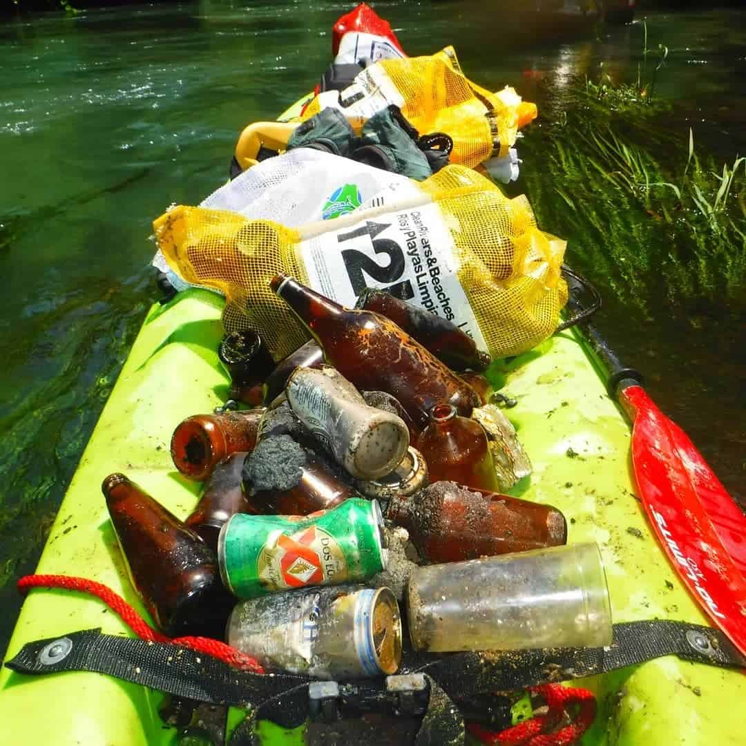 David Zambrano picks up trash in his kayak.