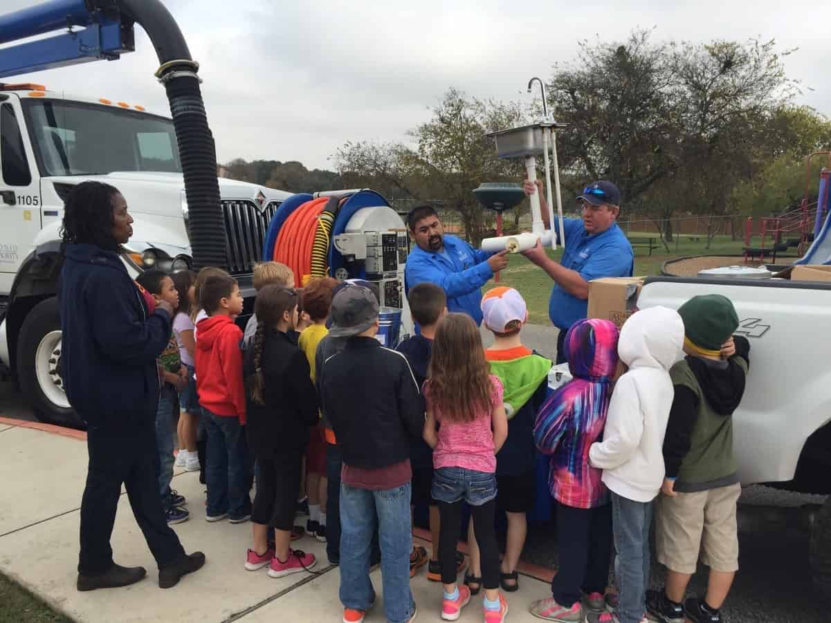 Staff from the River Authority Utilities Department demonstrate to students from Watts Elementary how pouring and washing fats, oils, and grease down the drain can cause grease build-up in pipes leading to major damage.