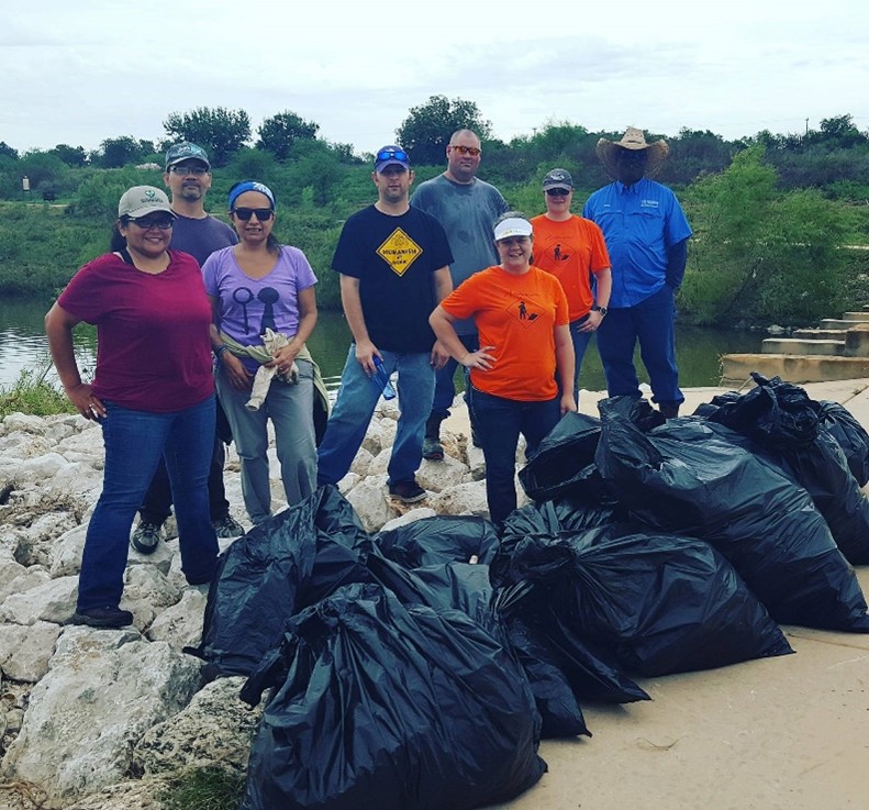 River Warriors cleaning up trash on the Mission Reach of the San Antonio River Walk following a storm event.