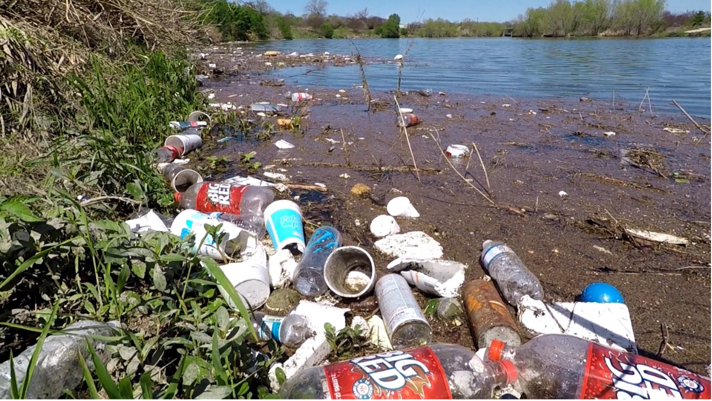 Plastic, styrofoam, and aluminum cans pile along the San Antonio River Banks after major storm event. 