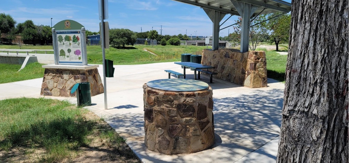 Apache Creek Park view of benches and directional signage.