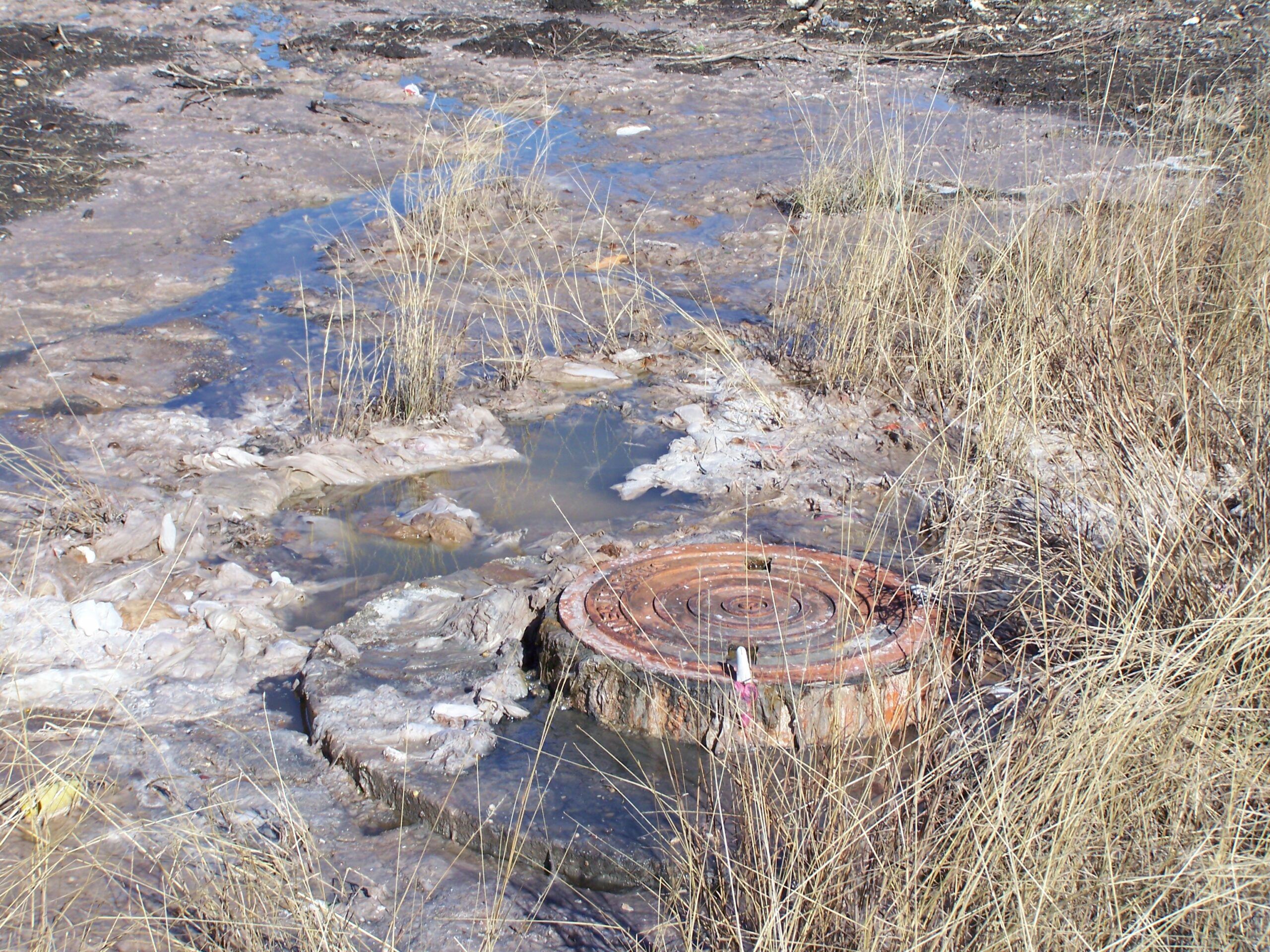 Improperly disposed wipes clog a sewer access hole