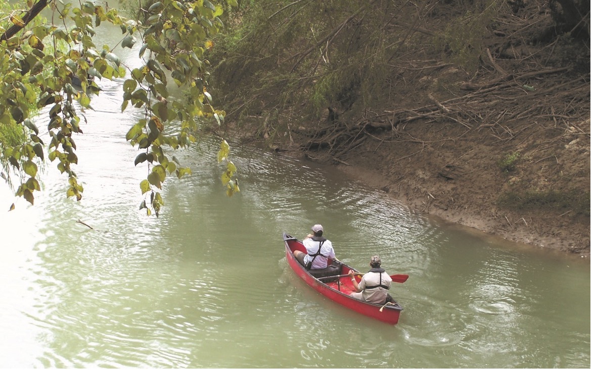 Two people kayak down the San Antonio River Basin. 