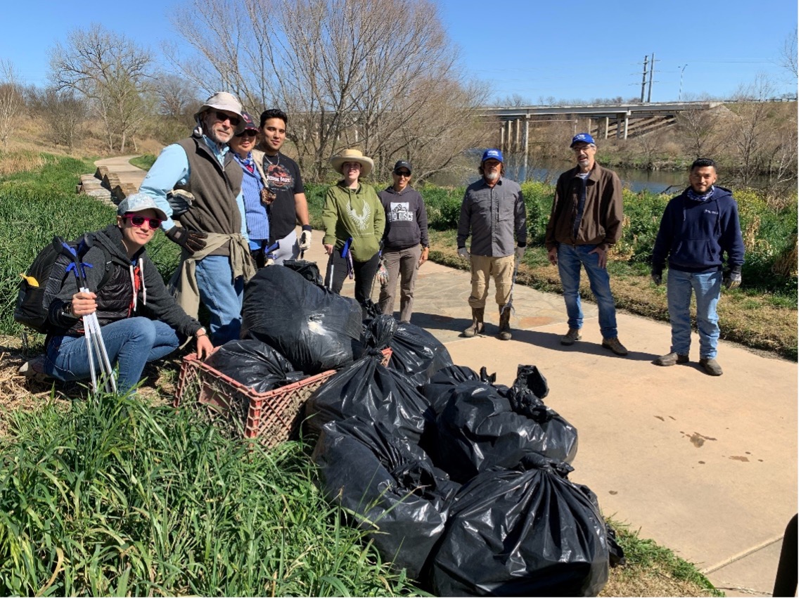 River Warrior Volunteers and River Authority Staff pose next to trash bags after a successful clean up.