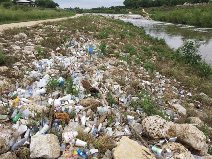 Trash covers the river bank after rain event