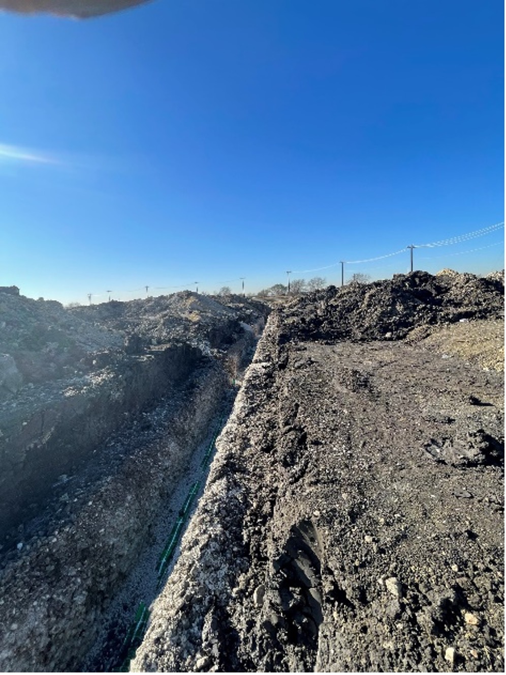 A new sewer main is installed in a trench. This will eventually be located under a roadway.