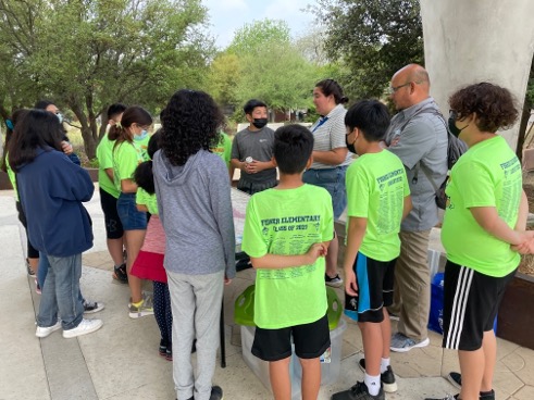 Group of student gather around Watershed Model at Confluence Park