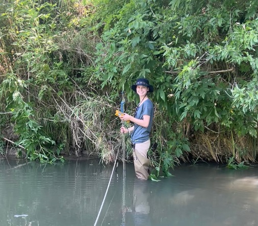 Olivia Reeves stands in the river during survey
