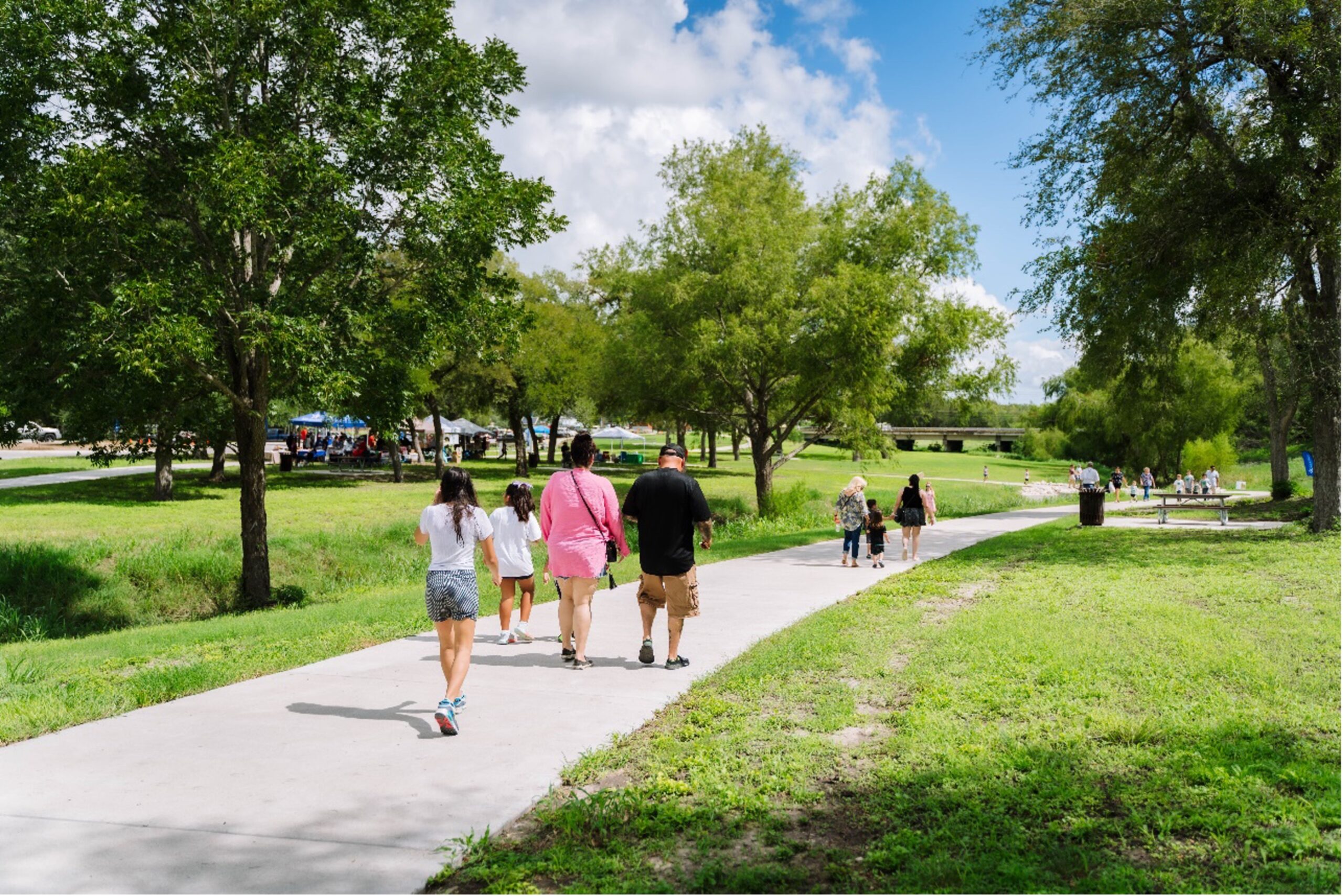 Families walk along a trail at Escondido Creek Parkway