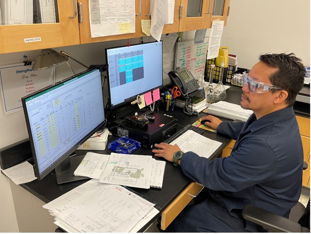 Technical Water Quality Scientist Greg Mateo enters sample results from an E. coli test.