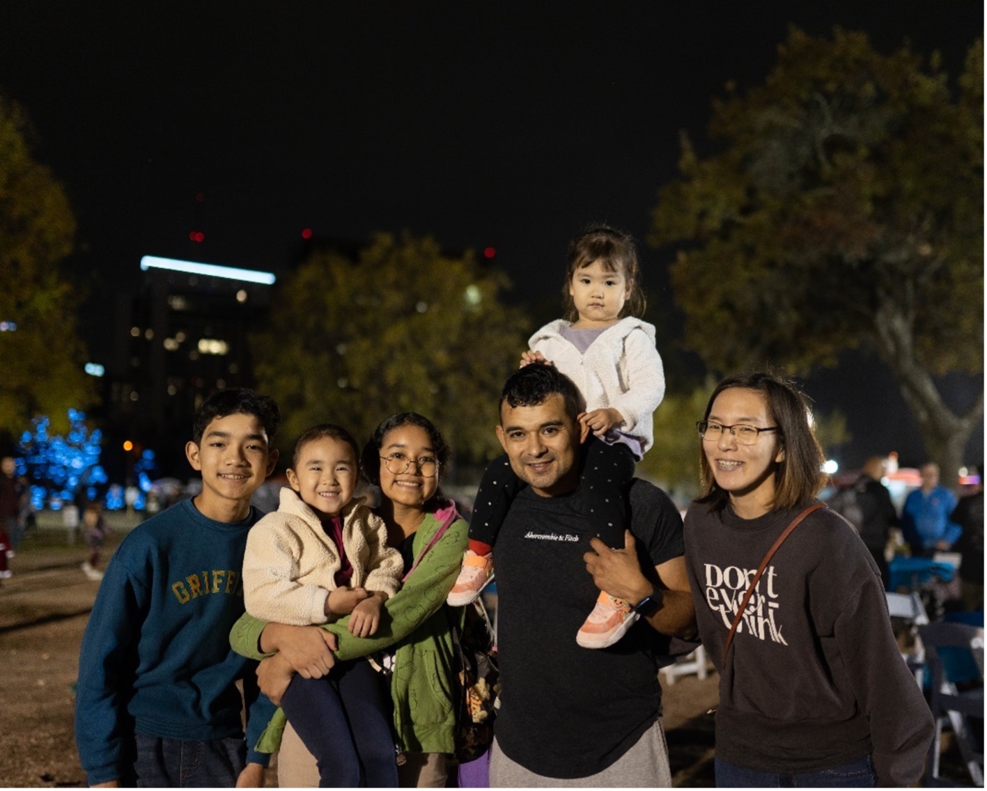 Family of 6 smile as they enjoy the River of Lights event