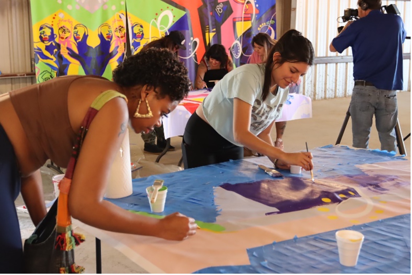 Art of Four participants painting the mural