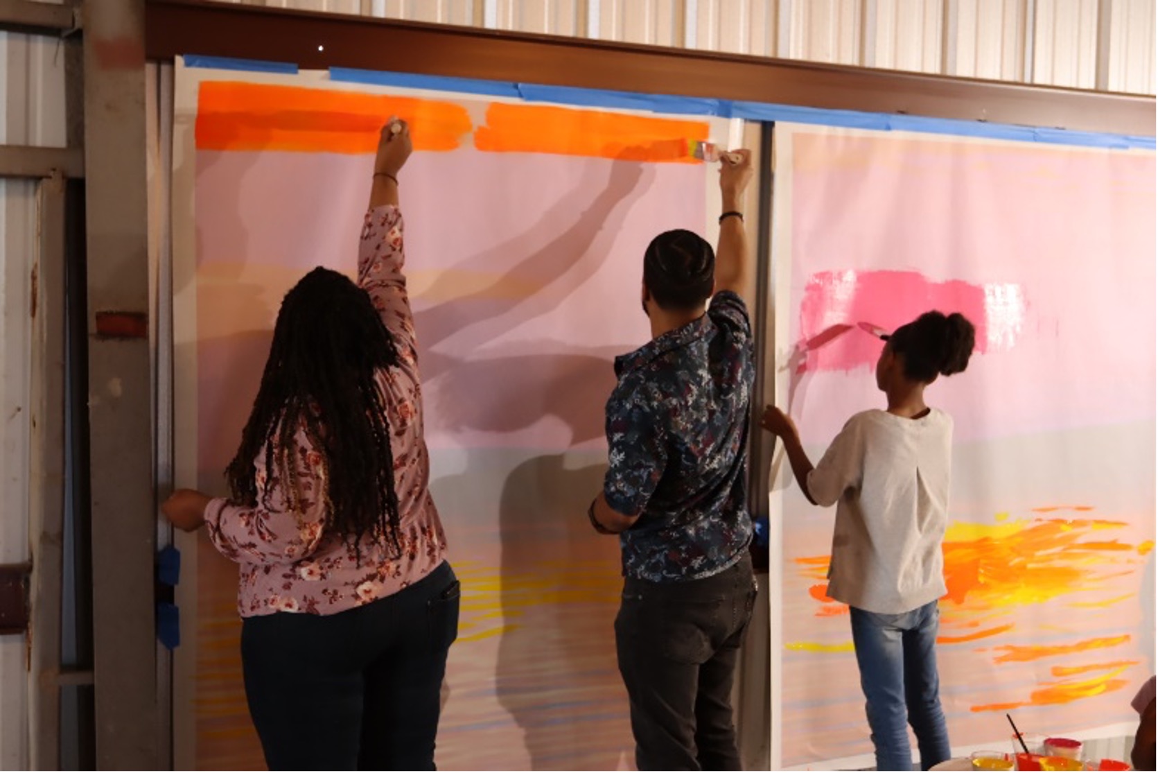 Art of Four participants painting a mural