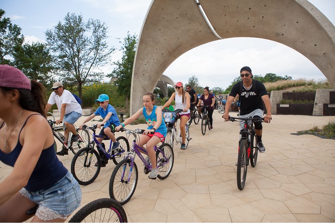 Cyclists ride through Confluence Park