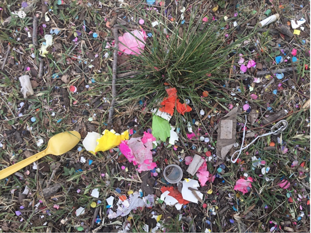 Confetti and plastic garbage litters the ground. 