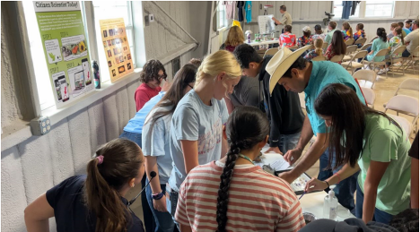 Students gather around water quality display model