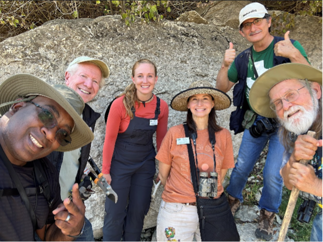 A group of people gather for a selfie after a successful nature observation event.