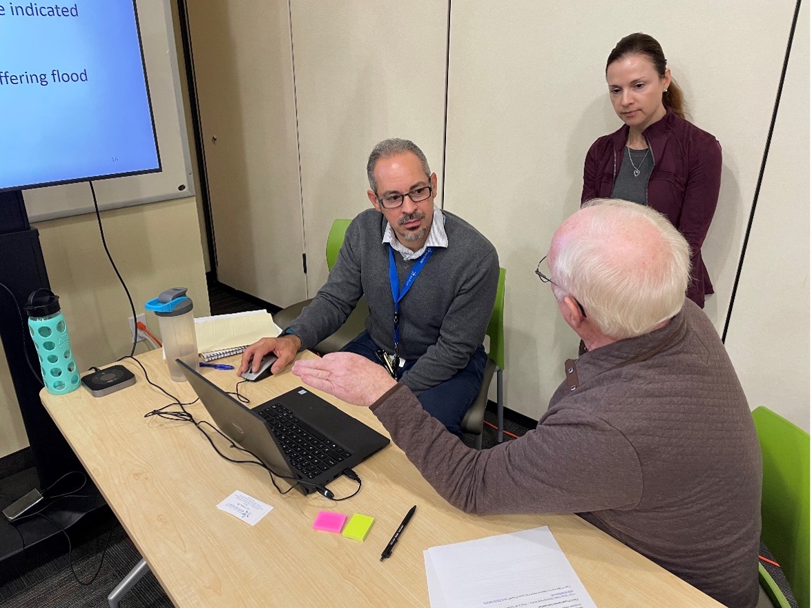 Engineers sit with constituents during draft floodplain meeting open house