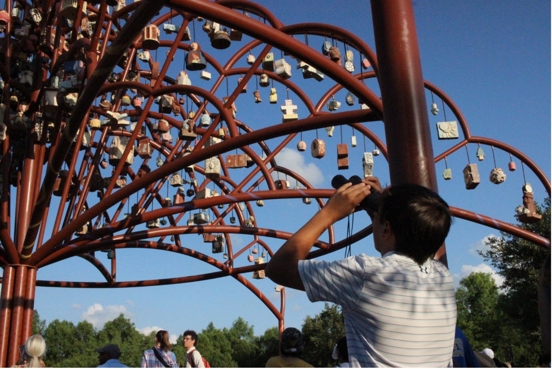 Person observes art sculpture using binoculars