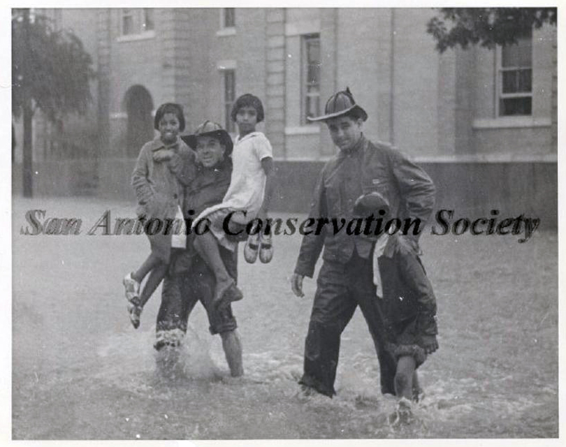 Historic image of firefighters saving children during flood