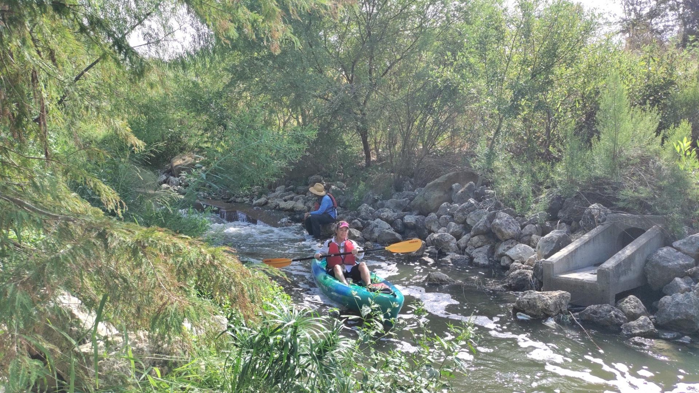 Kayak goers paddle downstream on the San Antonio River.