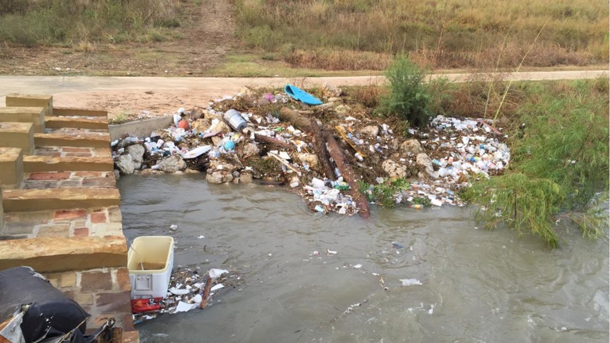 Trash collecting along river edge