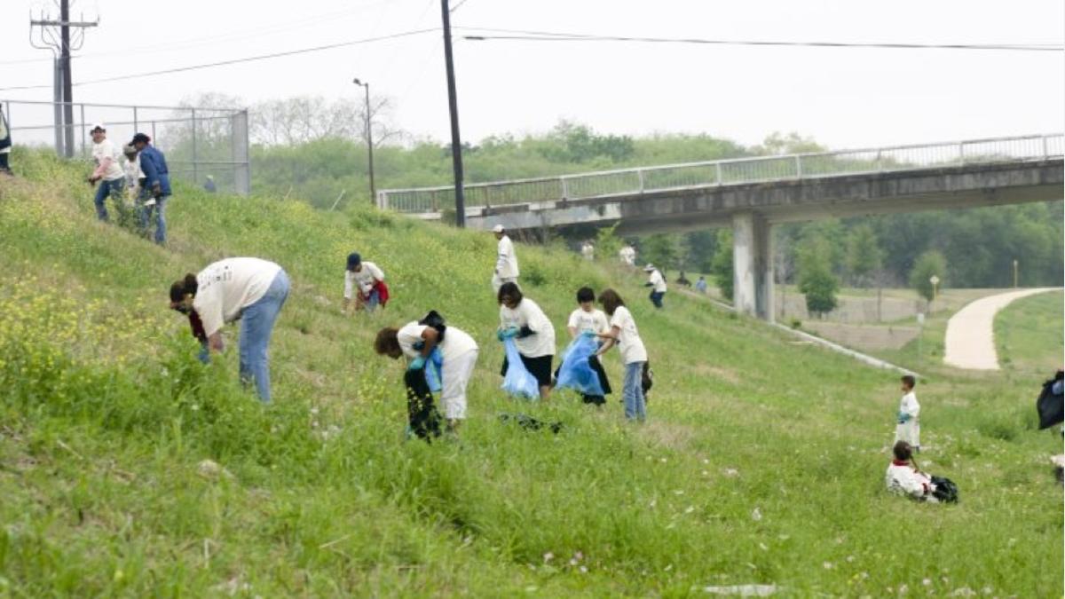 Volunteers collecting trash along river bank