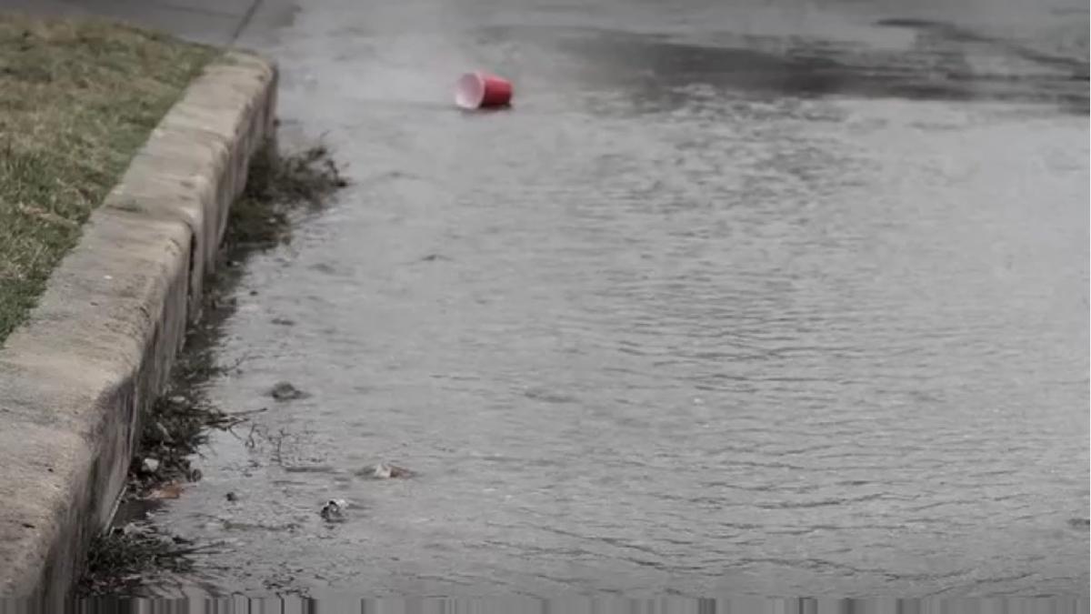 Trash flowing down flooded street