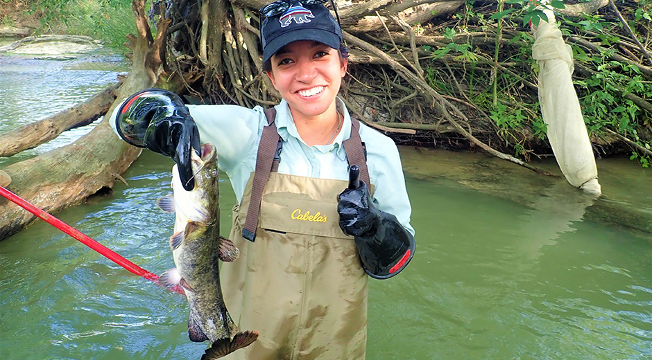 Woman in waders holding catch