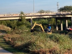 Backhoe in use along river edge