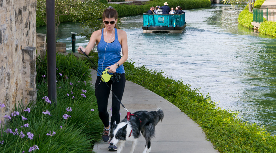 Walking dog along San Antonio River