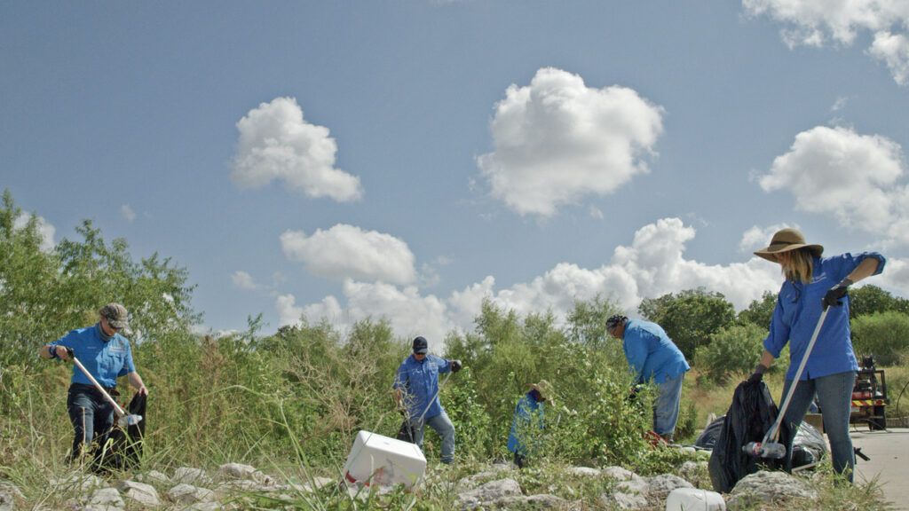 Volunteers cleaning up trash at river edge