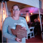 Woman stands with award