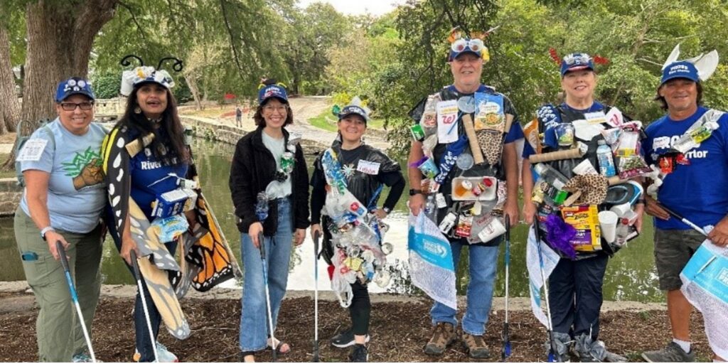 Volunteers stand side by side with their hand-made trash outfits.