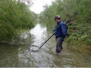 Man wades through water with net