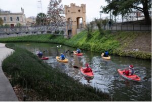 Kayaks go down the river during holly jolly kayaking event