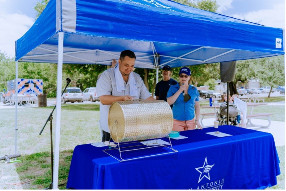 A man stands behind a table at the Kick off to Summer Bike Rodeo