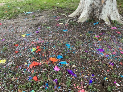 Confetti and plastic garbage litter the ground.
