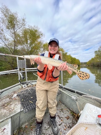 An aquatic biologist holds a long nose gar