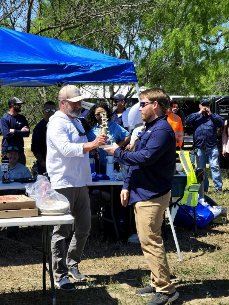 Chairman Jim Campbell shakes hands in congratulations with another River Authority employee 