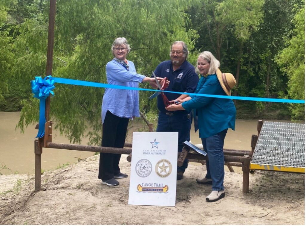Alicia Cowley cuts ribbon opening new paddling trail.