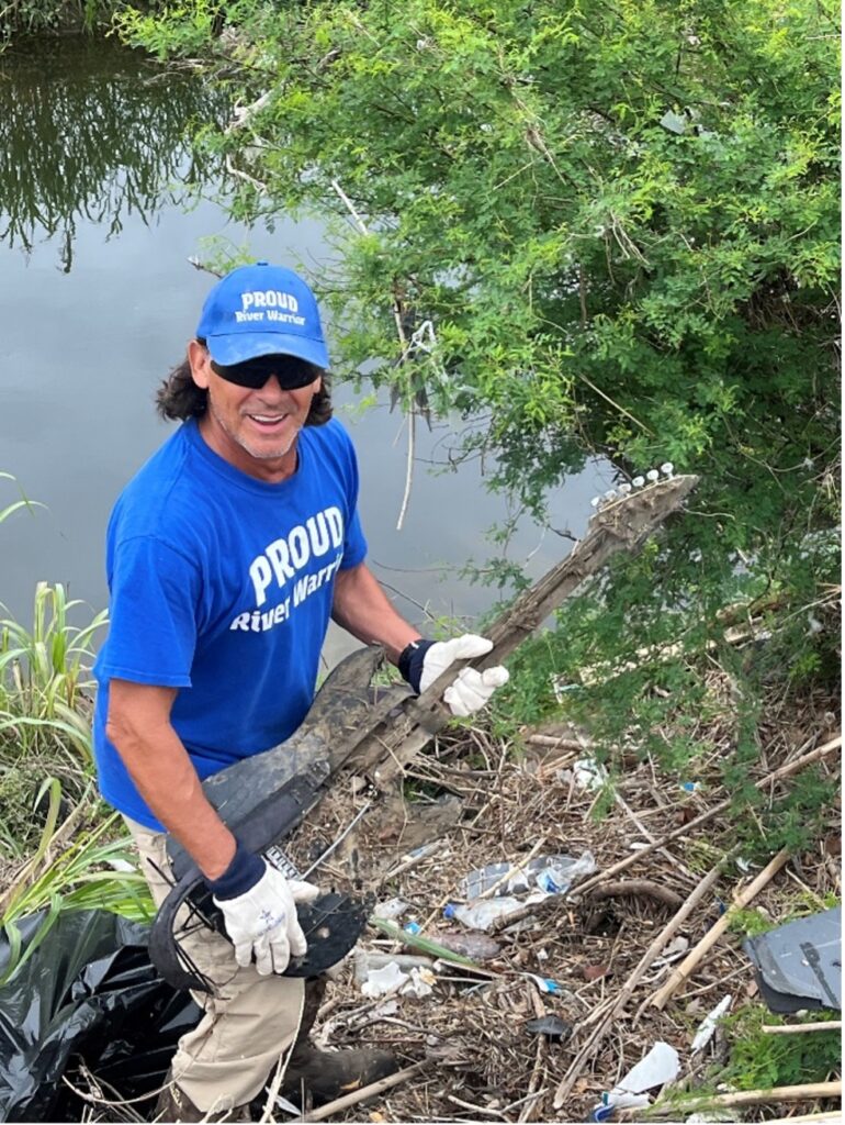 River Warrior picks up brush near the river 