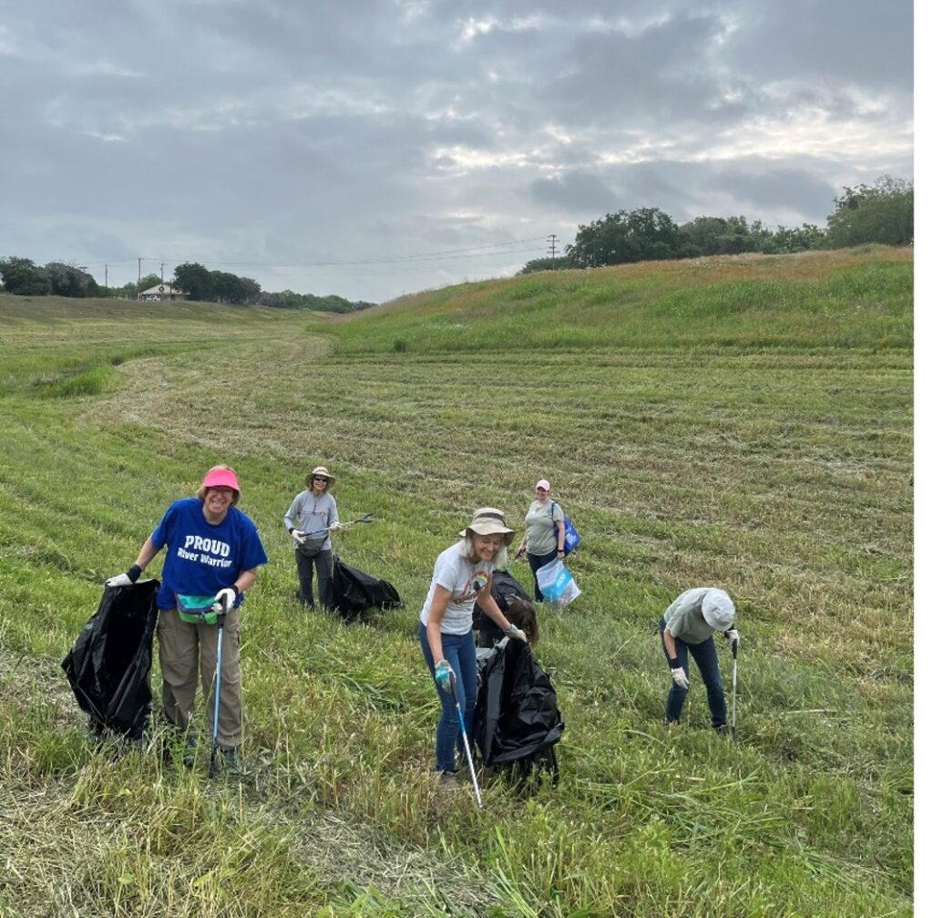 Group of volunteers picking up trash in a field