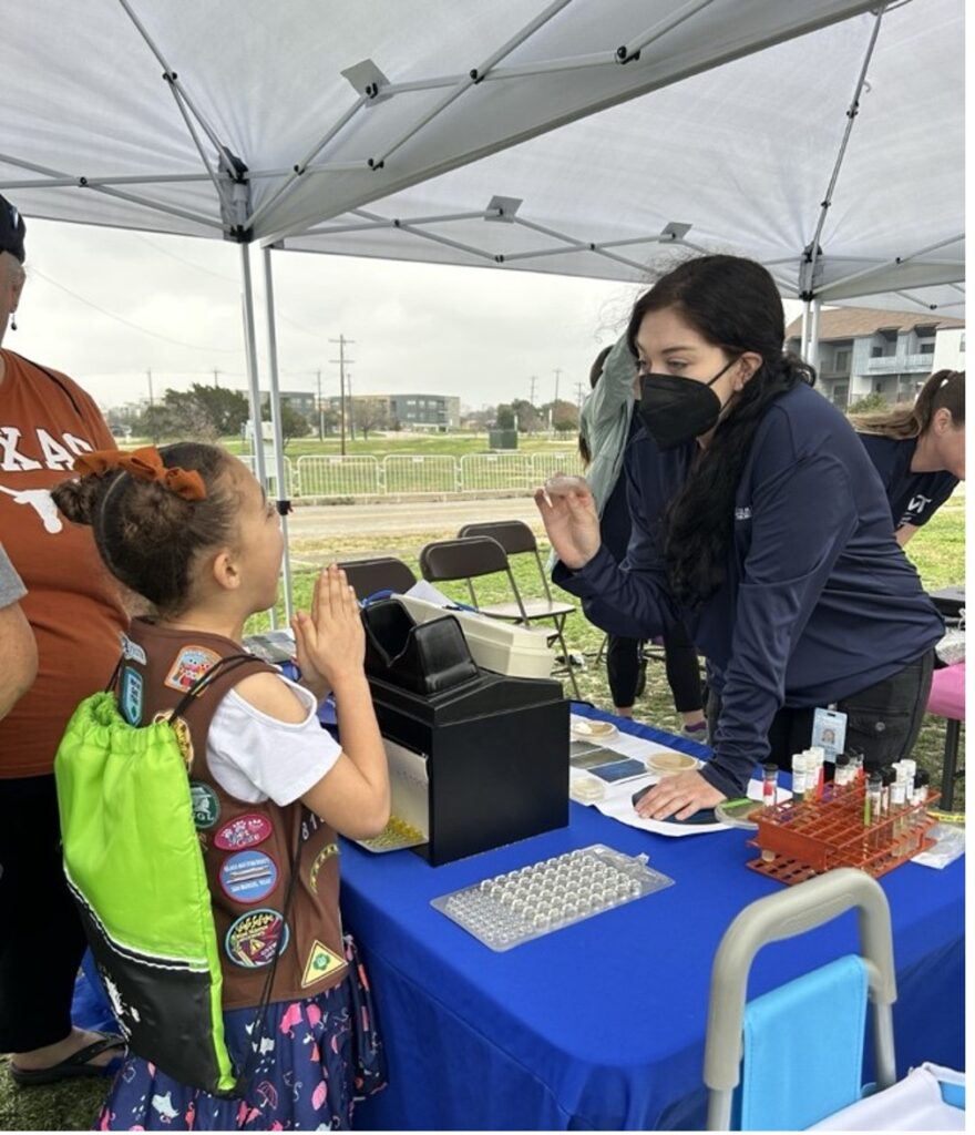 A young girl scout talks to a River Authority educator