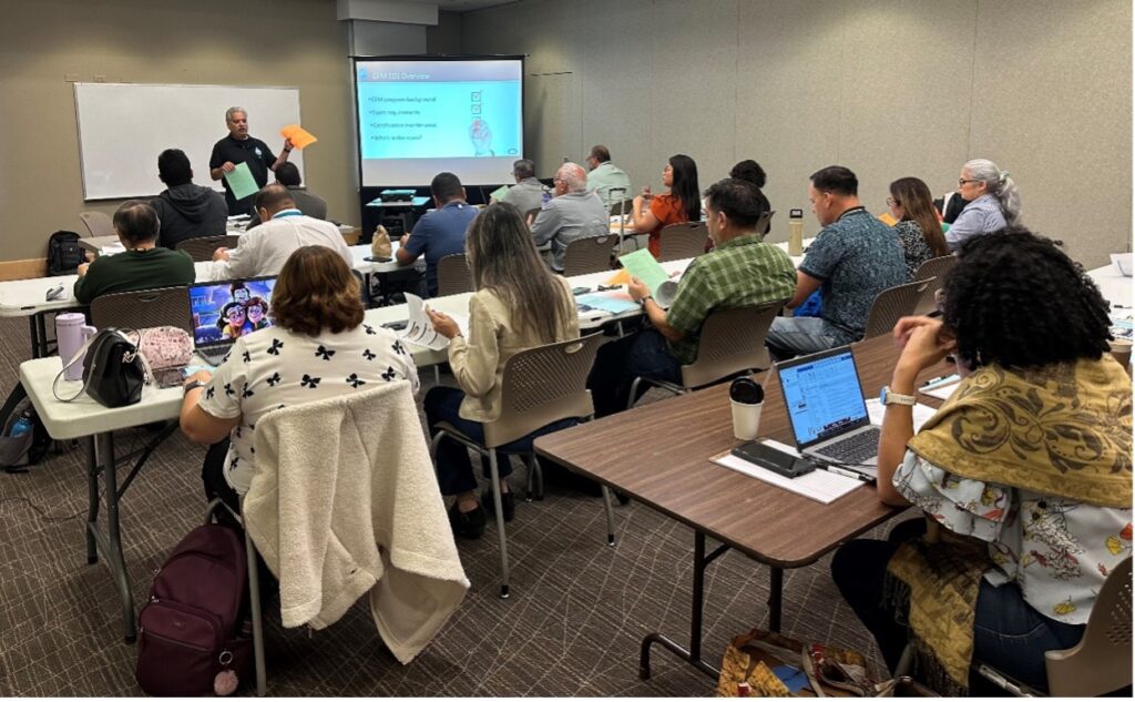 A group of people sit to listen to a presentation