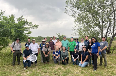 River warrior volunteers gather together in an open field.