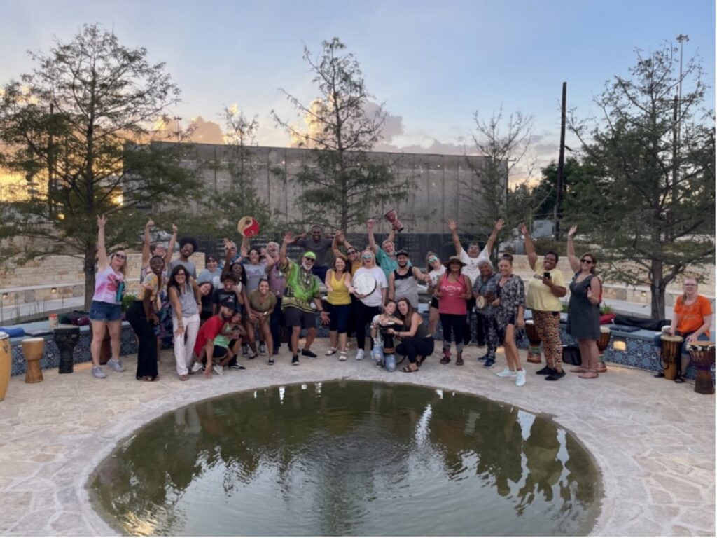 Drum Circle group takes a group picture in front of creek