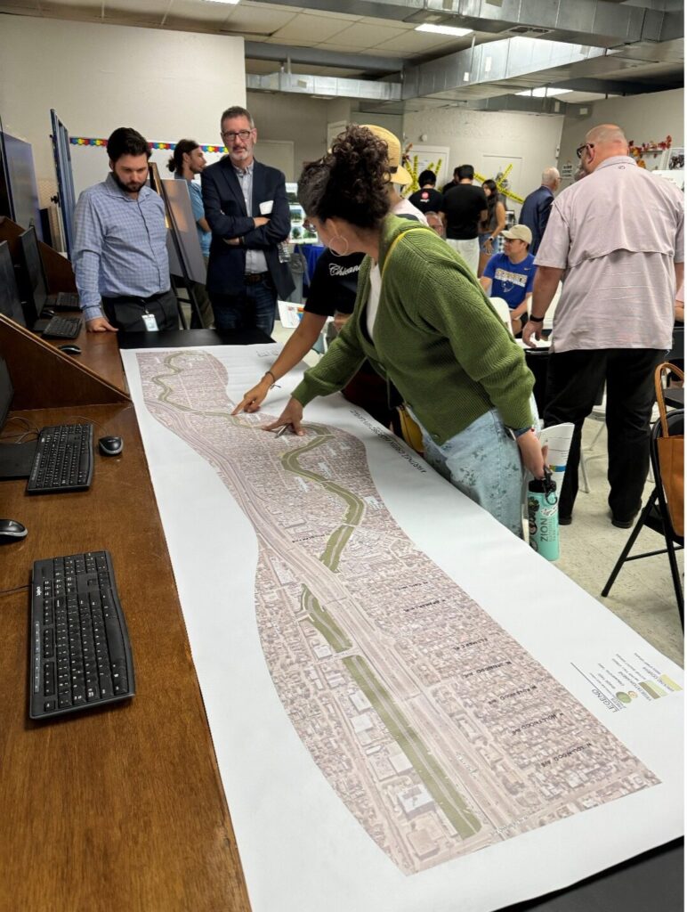 People surround a map on a table during the Westside Creeks Public Meetings