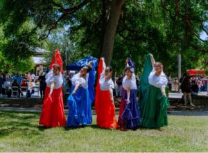 Five ballet folklorico dancers pose together.
