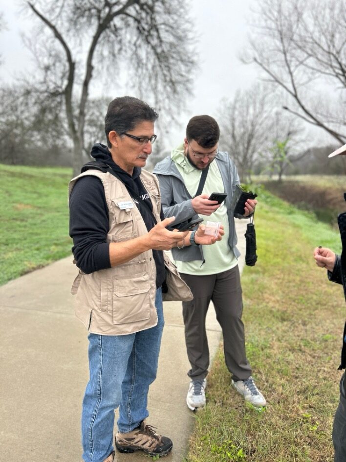 Two men on their phone conduct nature observations.